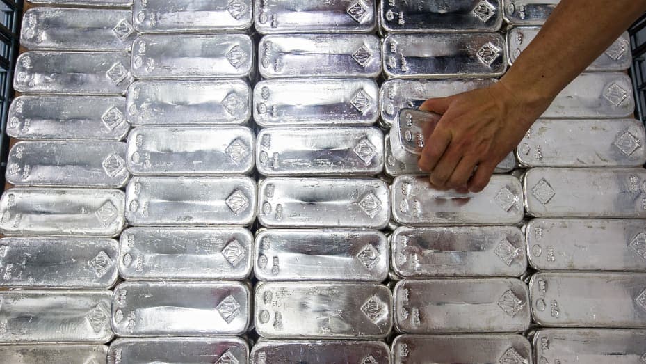 Barras de plata apiladas en una refinería